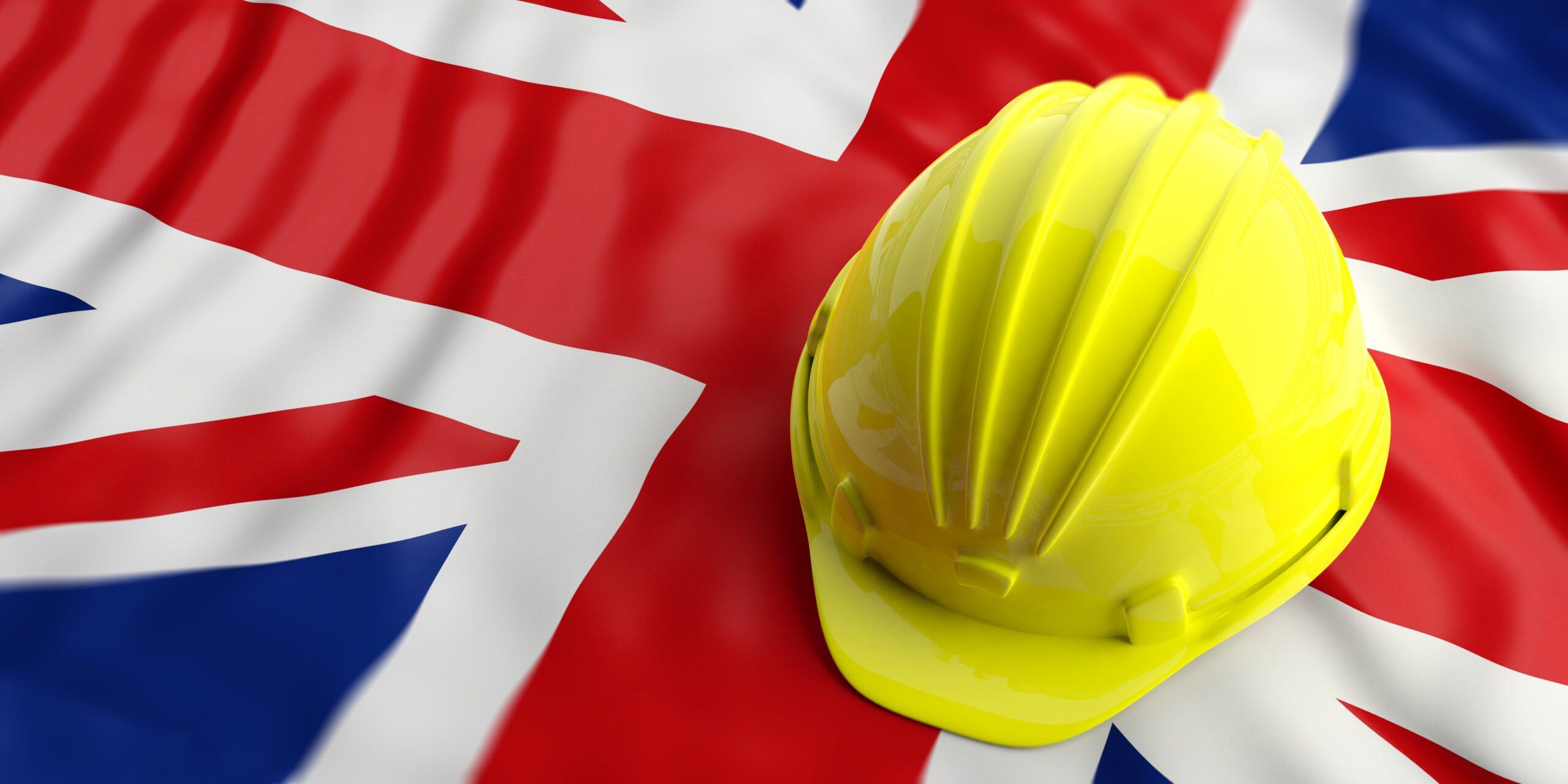 Yellow construction hat over UK flag hero image is PPE is for Life not just covid: The necessary role of personal protective equipment.