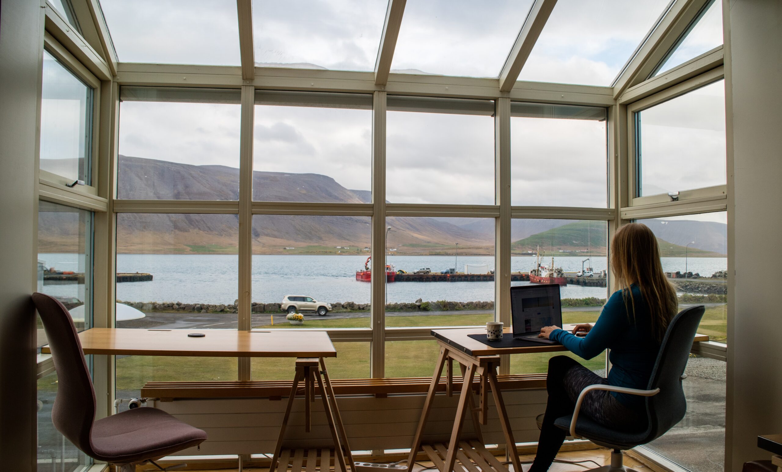 Hybrid and Remote Working Continuation image of woman working in a conservatory looking out at a lake and mountains