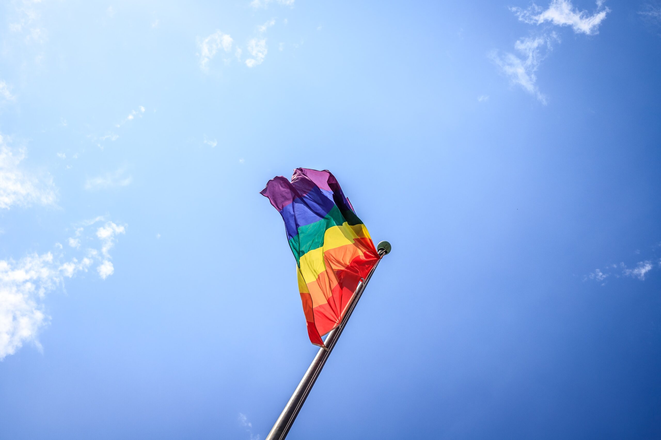 Promoting LGBTQ+ Inclusivity: 7 Essential Tips for a Safe and Supportive Workplace with pride flag in the sky